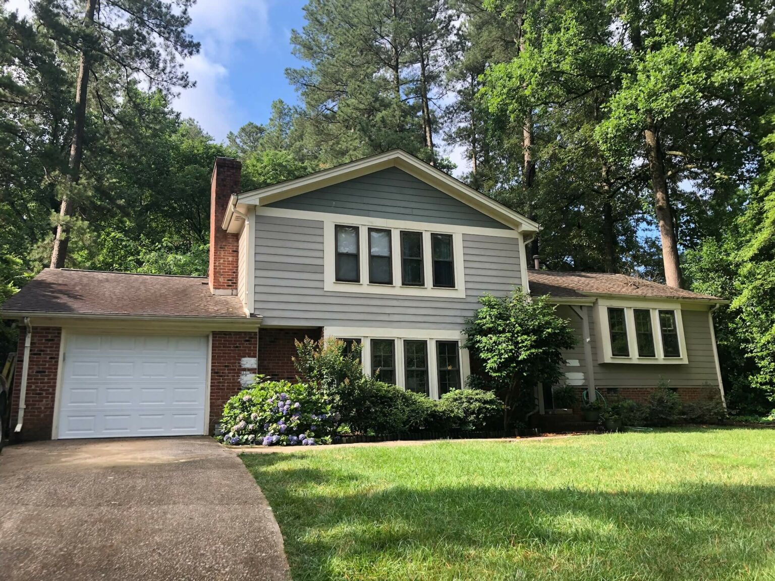 Cary, NC home with faded green siding before an Oak City Coatings exterior repaint