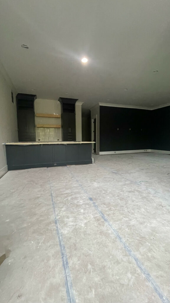 a room with a counter and recently painted dark cabinets