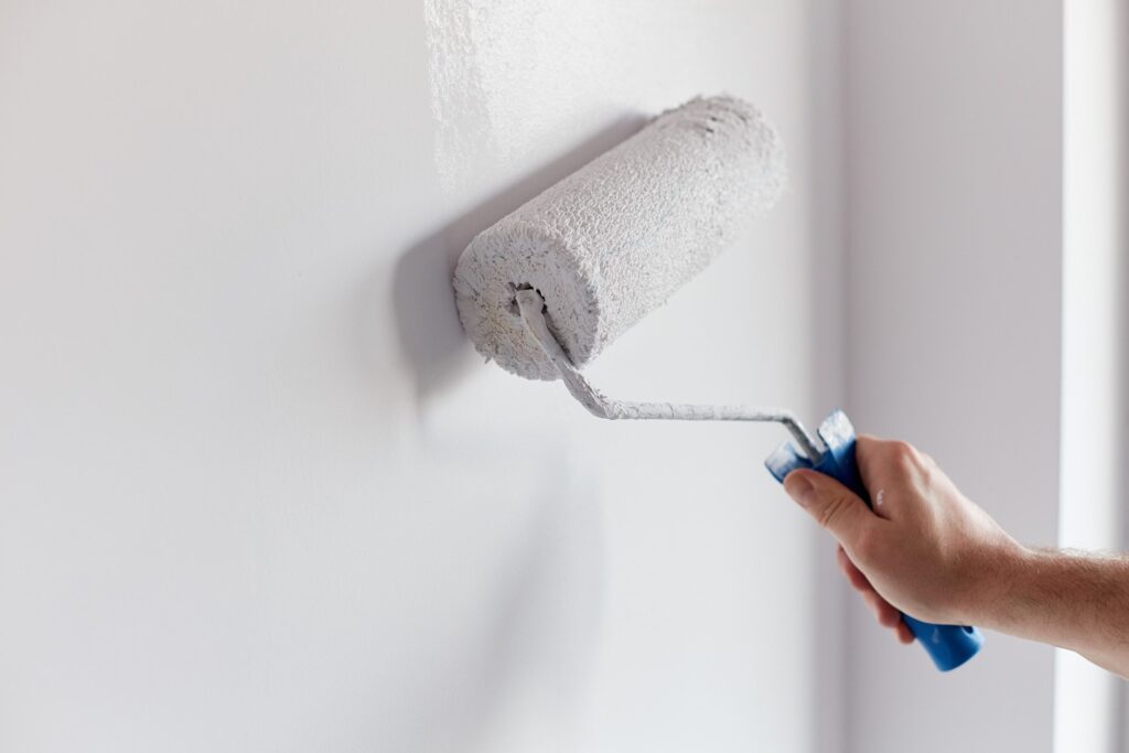 diy painter painting wall with primer