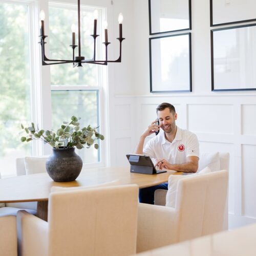 Nick O'Keefe, owner of Oak City Coatings, sitting in kitchen with white Matte walls