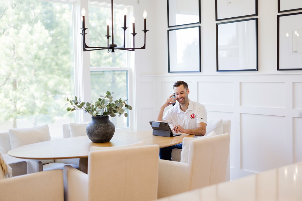 Nick O'Keefe, owner of Oak City Coatings, sitting in kitchen with white Matte walls