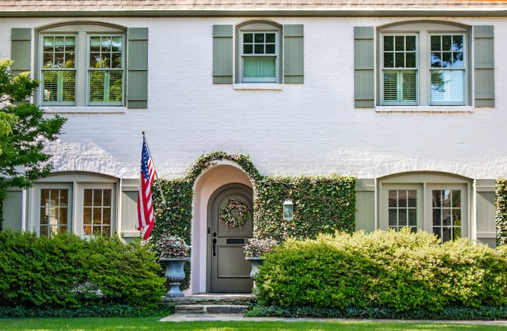 white masonry painted brick house with green painted shutters