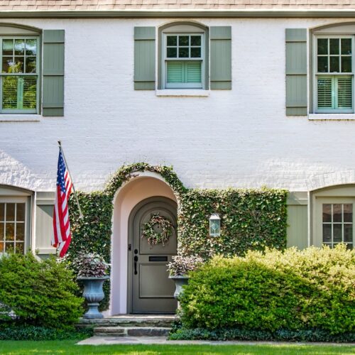 white masonry painted brick house with green painted shutters