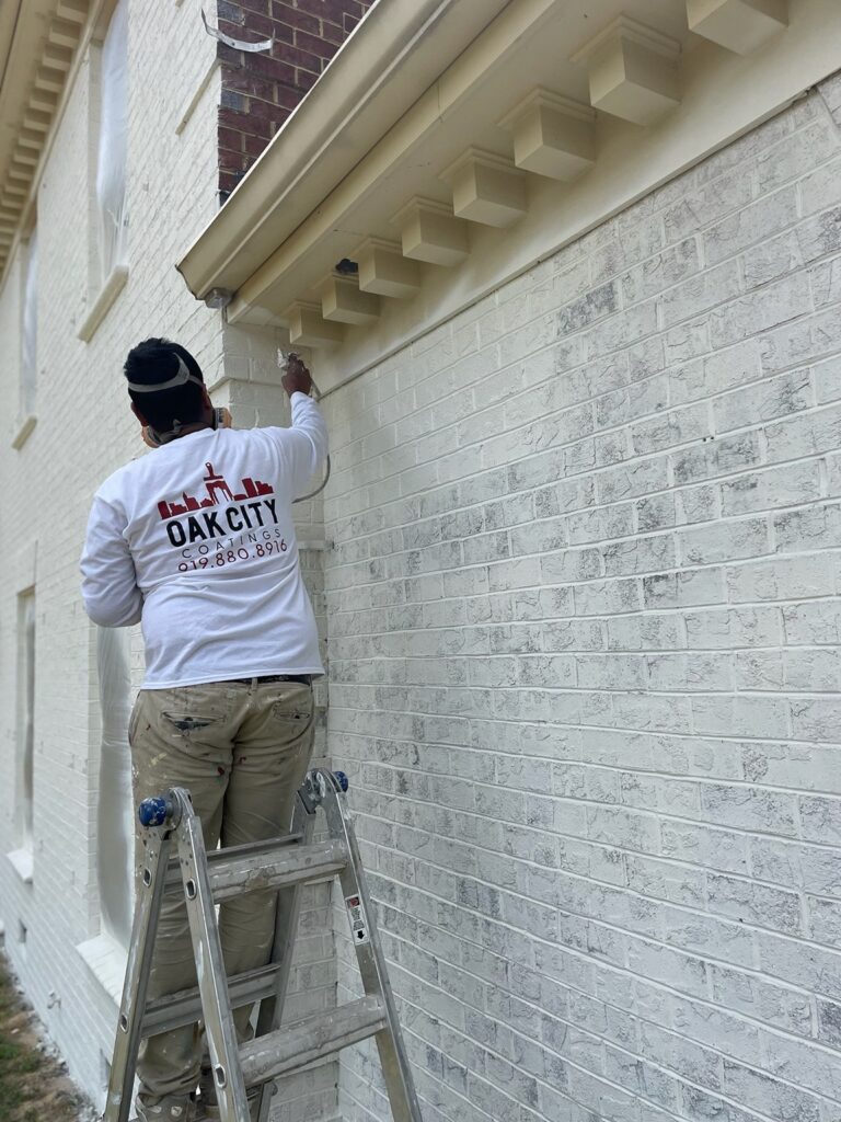 oak city coatings crew member limewashing brick house in Cary