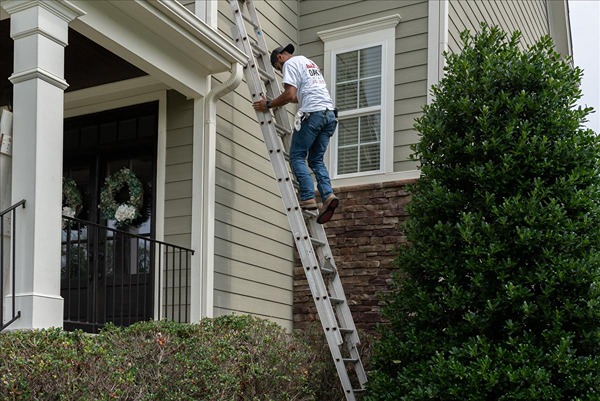 oak city coatings crew member climbing ladder during winter repaint