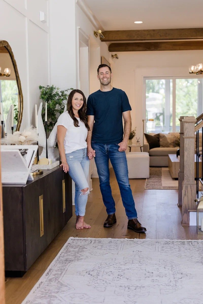 Oak City Coatings owners Nick and Stephanie O'Keefe, family-owned painting company in Raleigh, NC standing in entrance of house