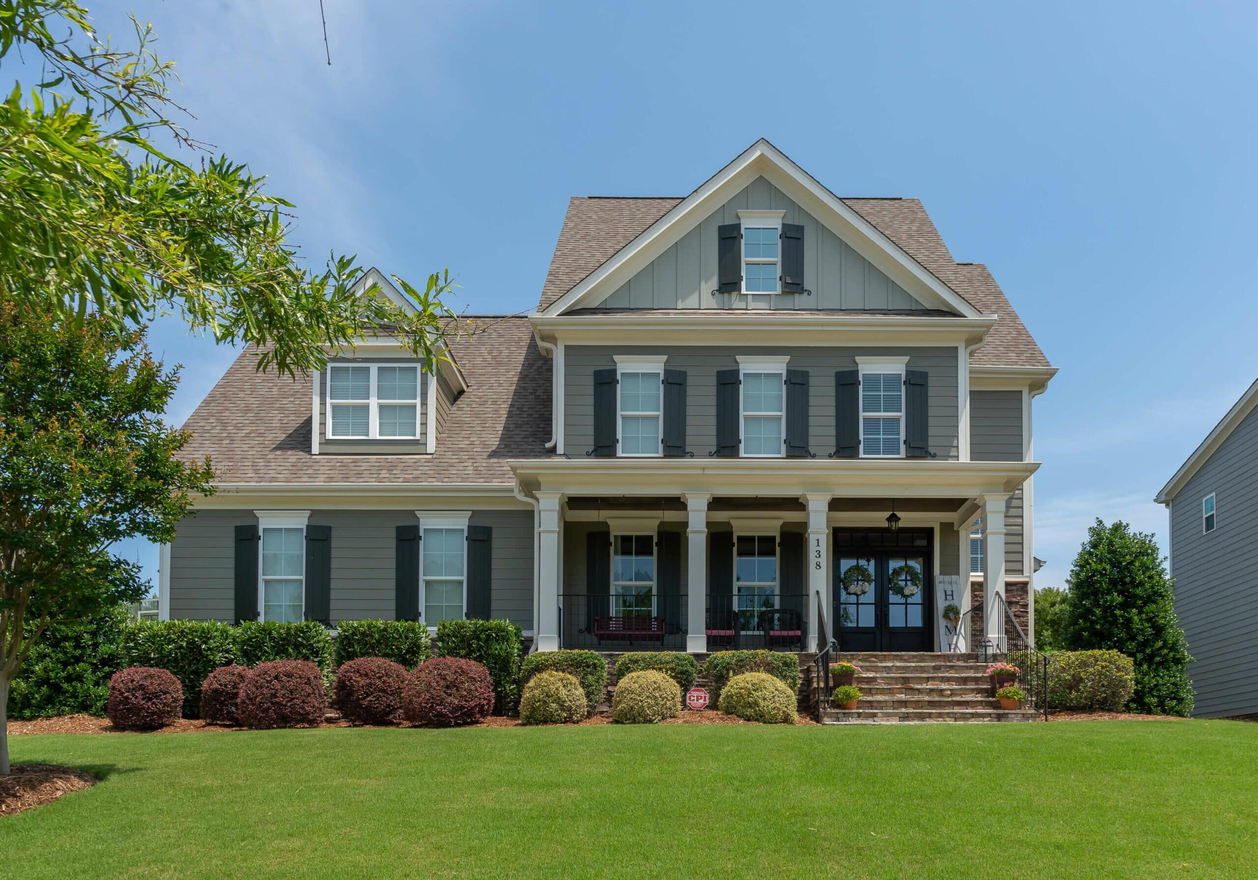 Freshly painted two-story home exterior at sunset by Oak City Coatings