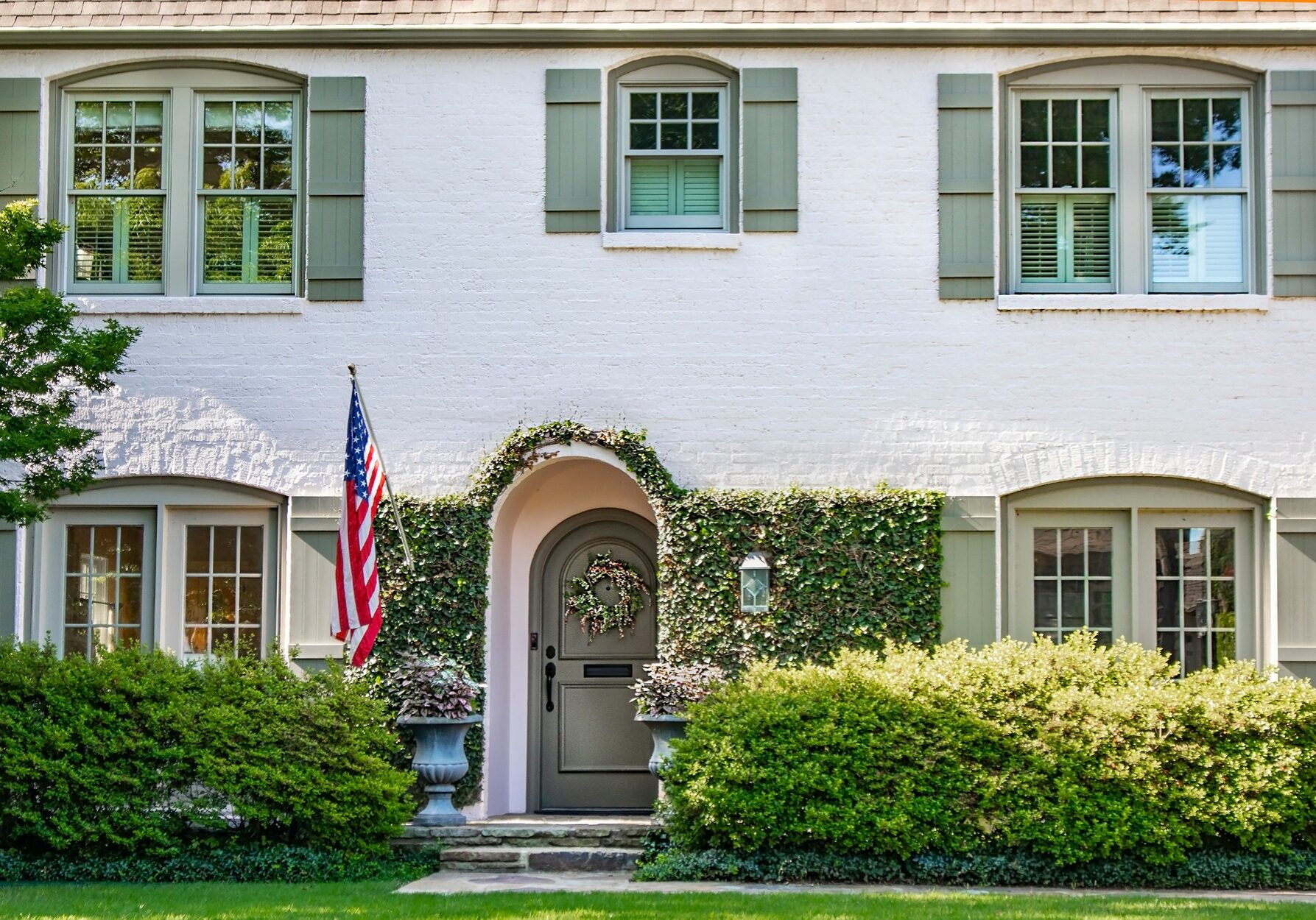 white masonry painted brick house with green painted shutters