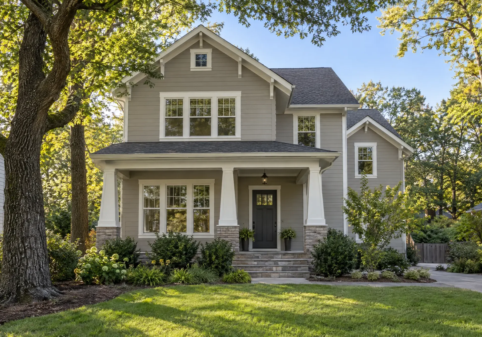Craftsman-style home with freshly painted greige siding, white trim and charcoal front door