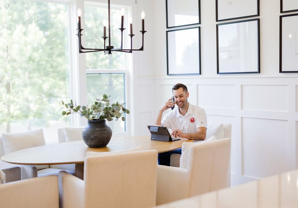 Nick O'Keefe, owner of Oak City Coatings, sitting in kitchen with white Matte walls
