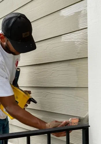 oak city coatings crew member painting exterior of house with paint brush in Fuquay-Varina