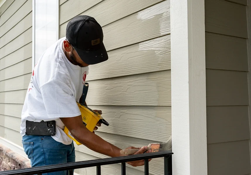 oak city coatings crew member painting exterior of house with paint brush in Fuquay-Varina