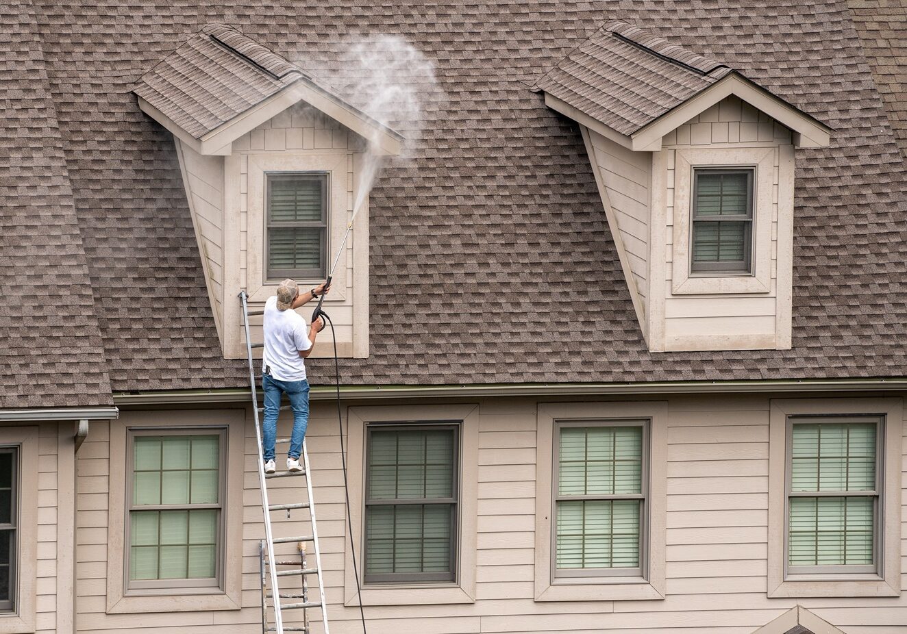 Oak City Coatings painters power washing house before painting