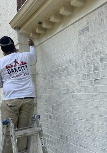 oak city coatings crew member limewashing brick house in Cary