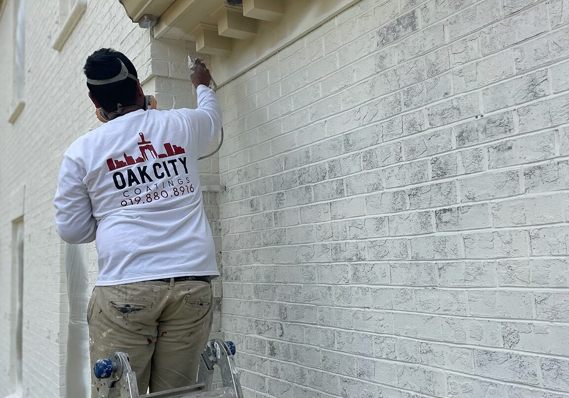oak city coatings crew member limewashing brick house in Cary